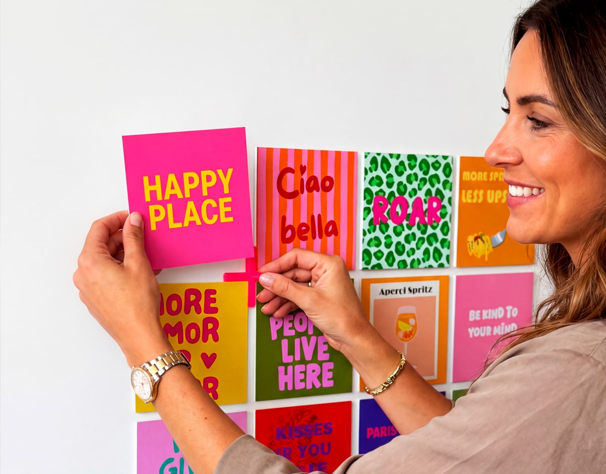 Eine Frau, die einen Happy shape an ihrer Wand neben anderen Happy shapes anbringt.